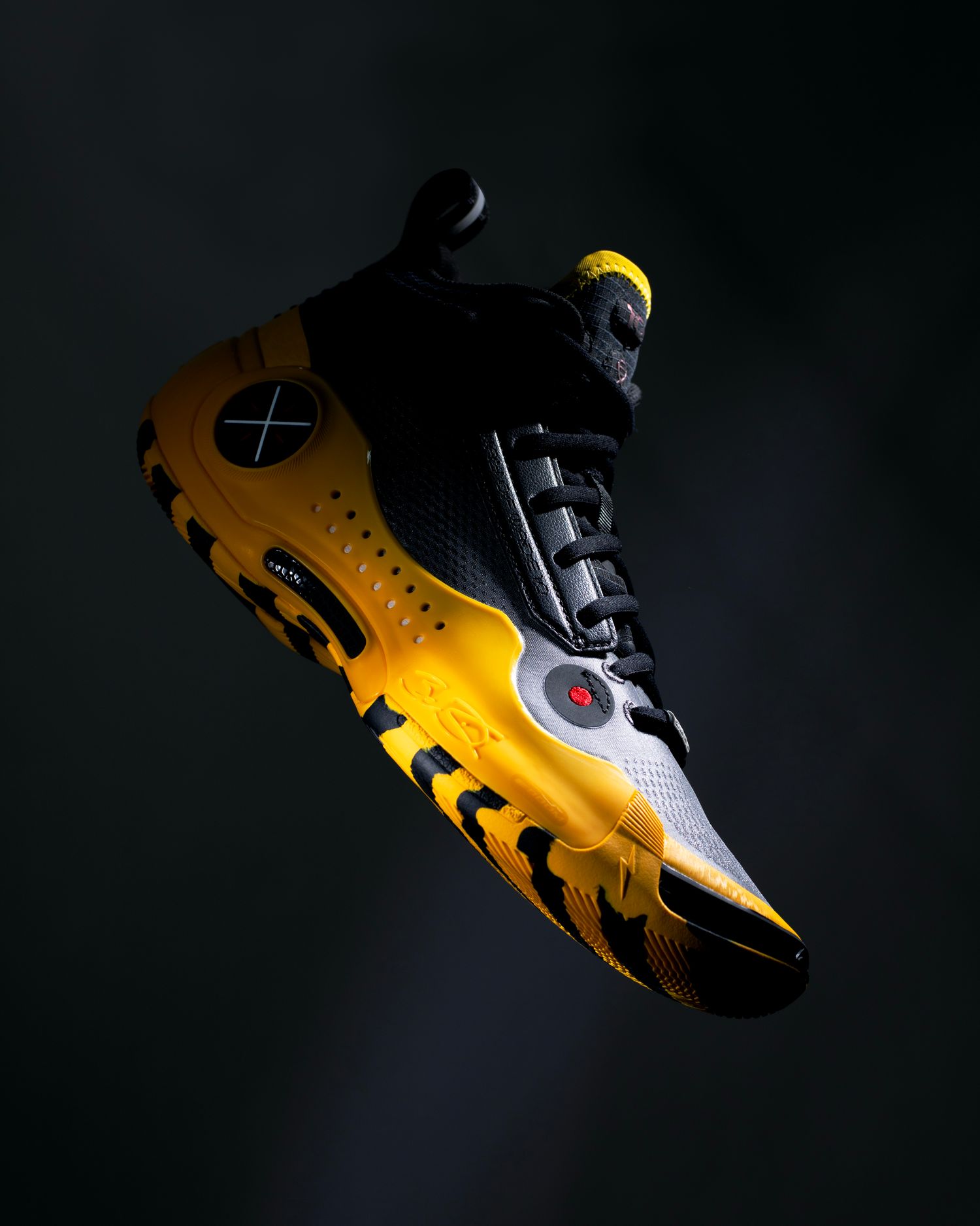 Side view of black and yellow Way of Wade basketball sneakers.